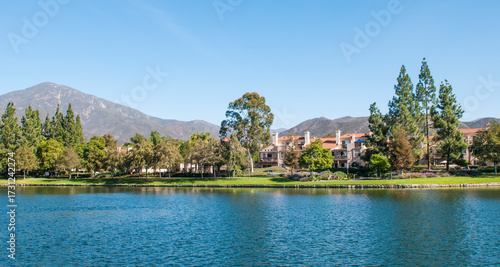 Lago en la ciudad de RANCHO SANTA MARGARITA en el condado de Orange en el estado de CALIFORNIA, Estadios Unidos de America. con montañas en el fondo y zona residencial entre arboles y parques.