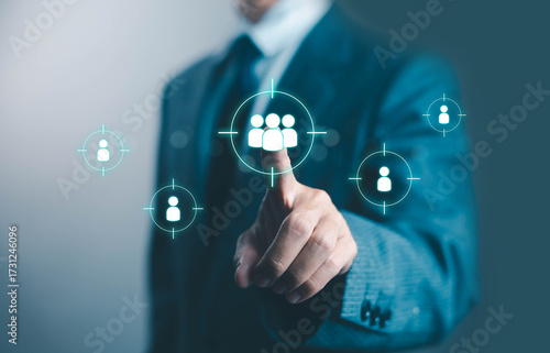 Businessman pointing at digital target group icons, concept of customer targeting, market segmentation, CRM strategy, digital marketing, and business network for client relationship management 