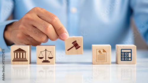 Legal gavel block held by hand with law court building scale document and calculator blocks representing labor rights and employment law concepts