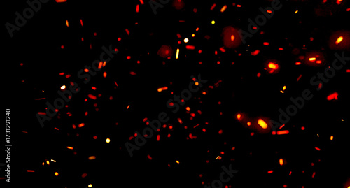 Dark abstract background with glowing orange sparks and embers floating in motion. The fiery particles create an energetic and dramatic atmosphere, ideal for heat, energy, flame, and fire concepts.