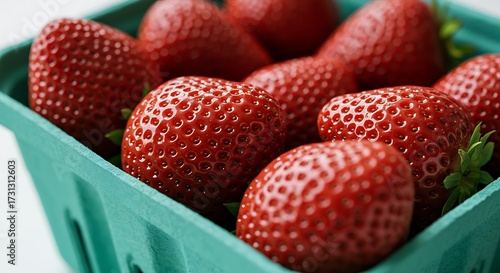 Fresh red strawberries in a green basket close up shot copy space
