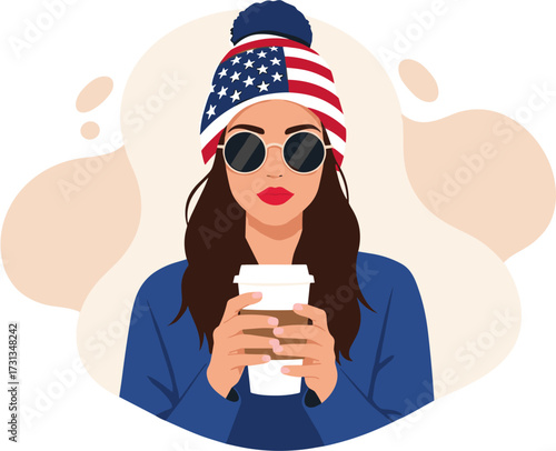 A fashionable young woman proudly displays her American spirit, wearing a stars and stripes beanie and trendy sunglasses while enjoying a warm beverage.