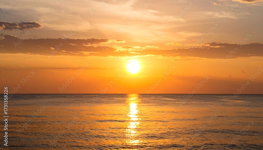 Fototapeta premium Golden sunset over calm ocean waters; sun's reflection visible on the surface