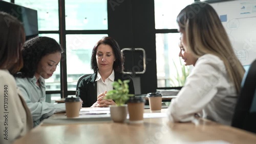 Team of young Asian woman talking in friendly meeting, business teamwork and corporate strategy session in daylight coworking space, group of female colleagues in professional conversation.