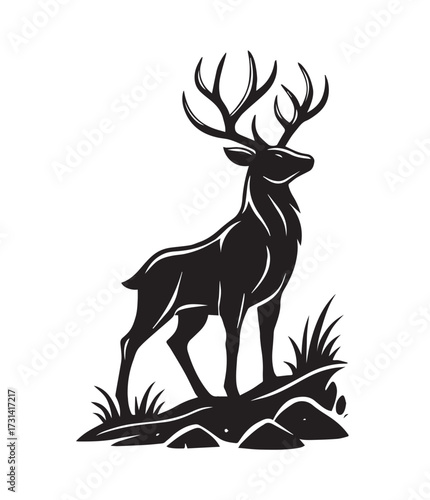 Black silhouette of a majestic stag with large antlers standing on a rocky outcrop with grass deer white
