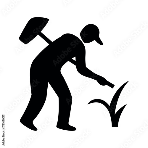 Silhouette of a gardener planting or weeding in a garden with a shovel