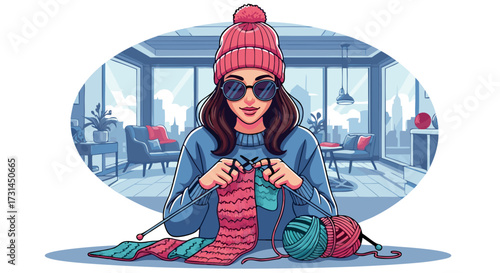 Young woman wearing sunglasses and a pink beanie happily knitting a pink scarf while sitting indoors with a cozy living room in the background