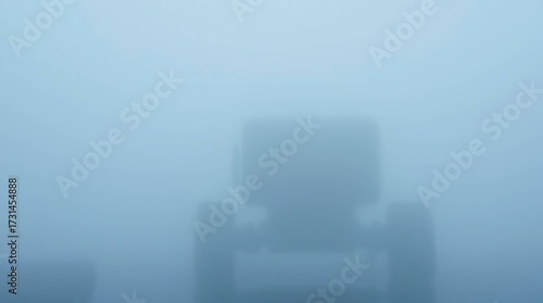 Tractor Silhouette in Foggy Field.