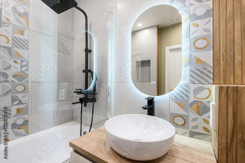 Εκτύπωση καμβά Elegant modern bathroom with white vessel sink on oak vanity, black faucet, abst