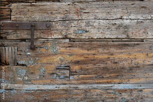 Εκτύπωση καμβά Old worn wooden door with inset repairs and a rusted metal adornment