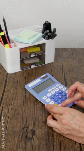 Women's hands take a calculator from the organizer and count on it, organizing the workplace