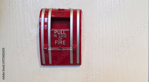Red fire alarm pull station on wall