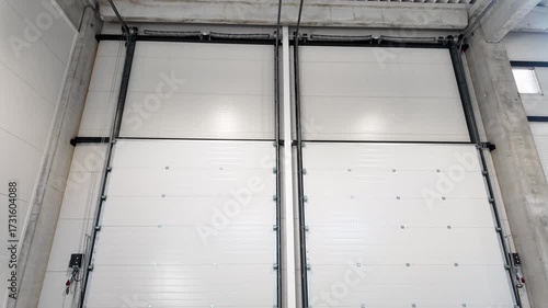 Automatic Roll Cargo Door at Big Warehouse. Sectional door in a large industrial building. Inside view