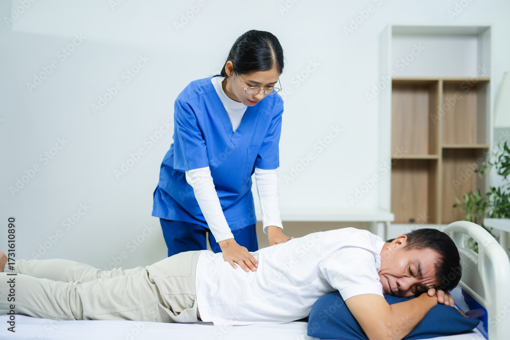 Fototapeta premium Nurse provides back massage to senior patient in clinic. Perfect for physiotherapy, rehabilitation, aging care, wellness, pain relief, and professional healthcare themes.