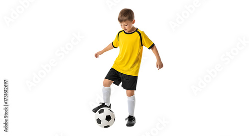 Young soccer player in yellow jersey practicing with ball