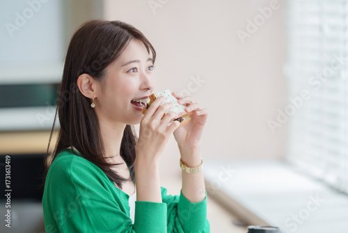 Plakat w ramie サンドイッチを食べる女性