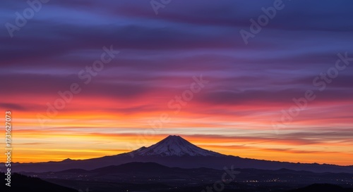 Majestic mountain silhouette against a vibrant colorful sunset sky with dynamic cloud formations