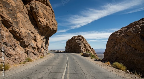 Scenic road through imposing rock formations under a vibrant blue sky suitable for travel and landscape imagery