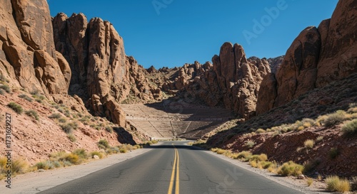 Scenic road through rugged canyon landscape under a clear blue sky with copy space