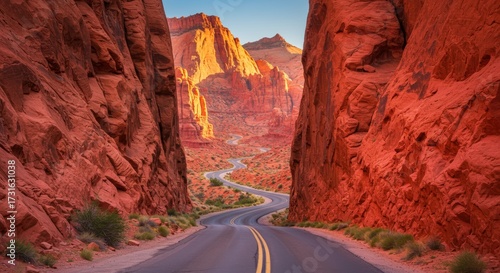 Scenic road winding through towering red rock formations under a clear blue sky daytime view