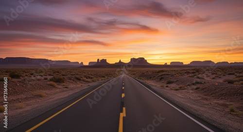 Open road leading into a sunset with mountains and clouds asphalt surface wide angle view
