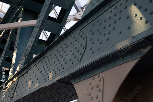Close up view of steel bridge structure with visible bolts and rivets, strength and engineering behind design. Industrial and architectural detail emphasizing precision and durability