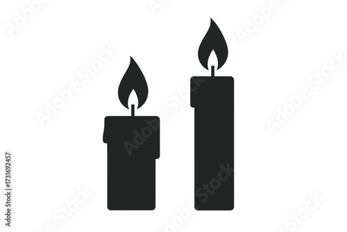 Two black candles with flames on a simple background representing Rosh Hashanah  