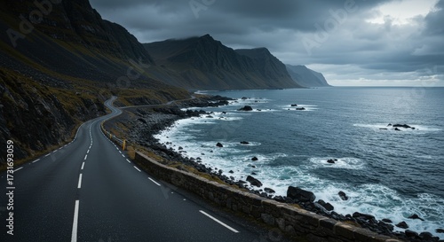 Scenic coastal road winding along the shoreline under dramatic cloudy sky travel and outdoor imagery