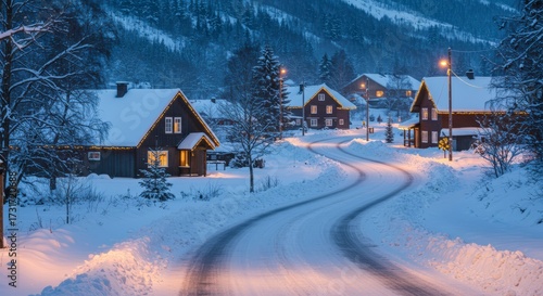 Snowy village scene with illuminated homes along winding road during winter evening