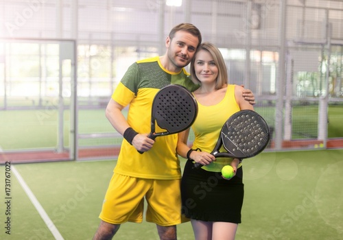 Couple Posing with Padel Rackets on Court
