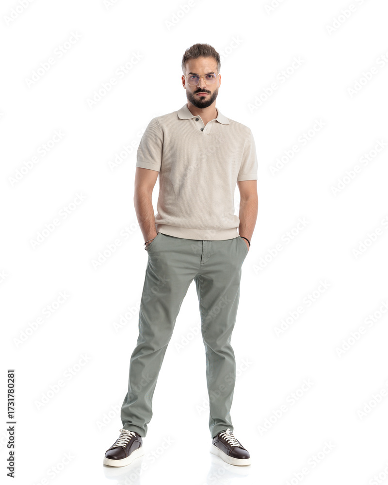 Fototapeta premium cool casual guy with glasses holding hands in pockets and standing
