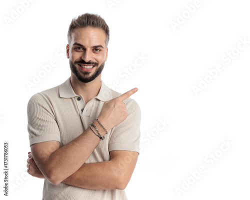happy casual man in polo shirt smiling and pointing fingers to side