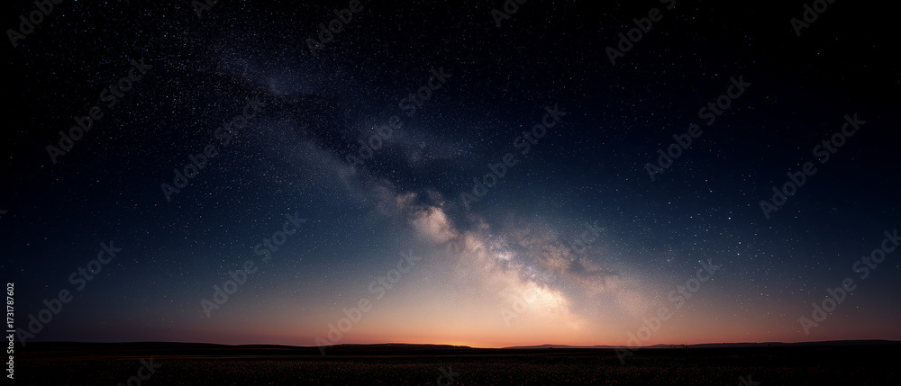 Fototapeta premium Milky Way Galaxy Spanning Night Sky Over Dark Horizon