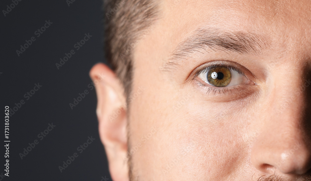 Fototapeta premium Man with beautiful eyes on black background, closeup. Space for text