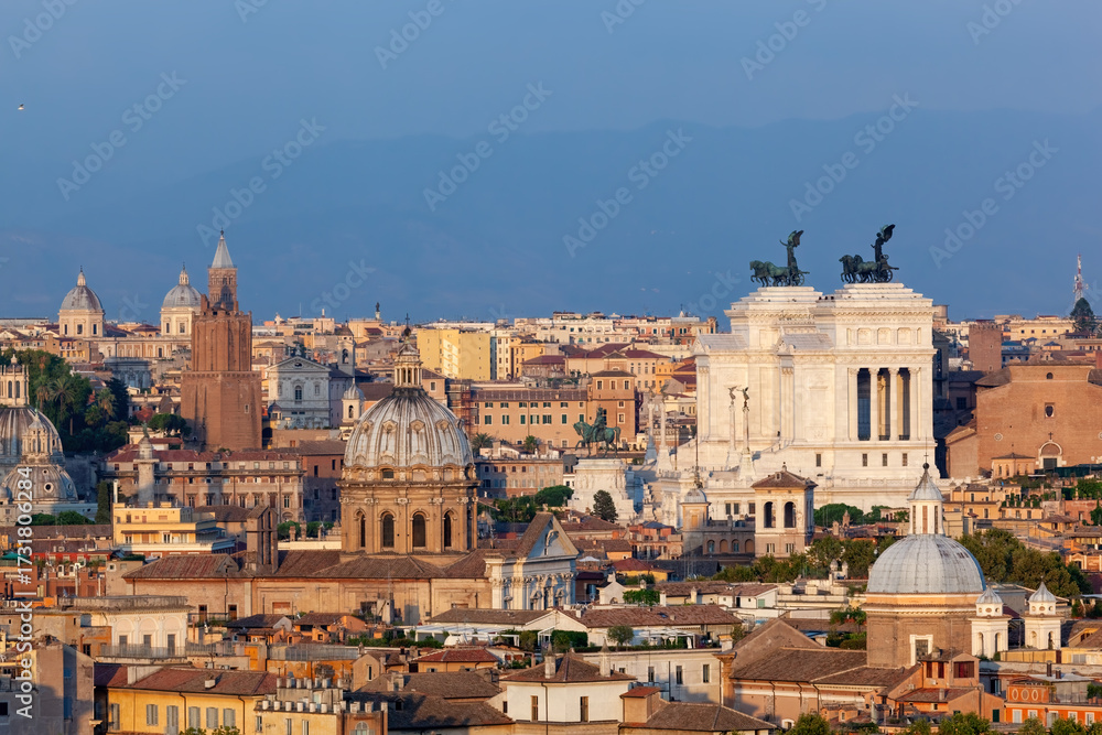 Fototapeta premium Panoramic view of Rome's historic cityscape under a clear blue sky at sunset