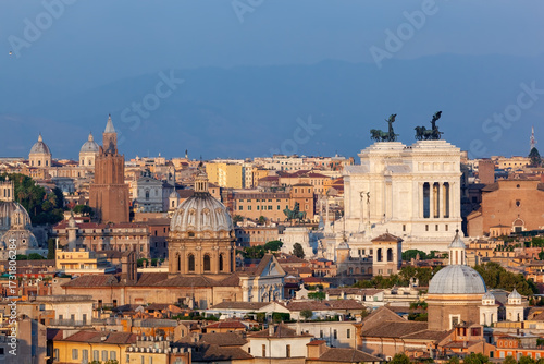 Panoramic view of Rome's historic cityscape under a clear blue sky at sunset