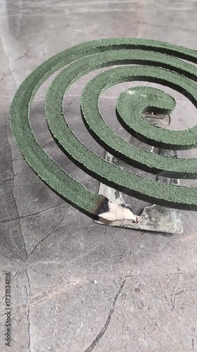 A Green Spiral Mosquito Coil placed on a stylish Glass Base for added aesthetic appeal