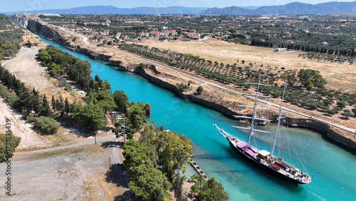 Aerial drone photo of classic sailing boat crossing narrow Corinth canal of Isthmus from West submersible bridge and narrow opening of Corinthian gulf to Saronic gulf, Loutraki, Greece