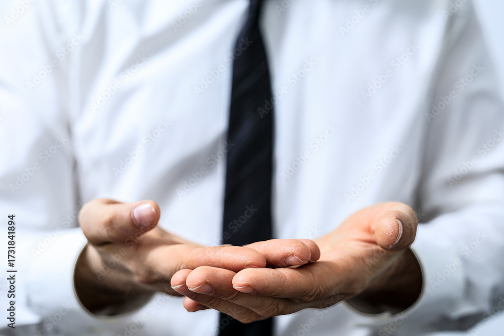 Fototapeta premium Close-up of businessman in a white shirt and tie, holding out his hands, symbolizing giving, receiving, or offering something, concept and gestu