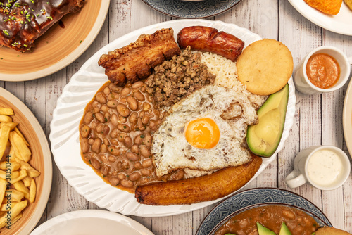 Arroz atollado (rice atolla) with chicken, pork, and seafood, mixed with vegetables and seasonings, served in a shiny metal cauldron