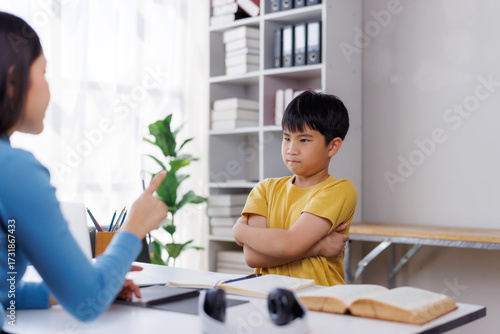 Tableau sur toile Asian teacher scolding a stubborn student at school desk