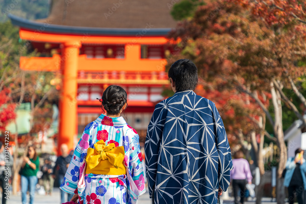 Fototapeta premium Couple wearing traditional japanese kimono clothes walking towards shrine in Kyoto 