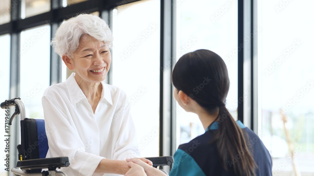 Obraz premium 介護士に感謝を伝えるアジア人高齢者