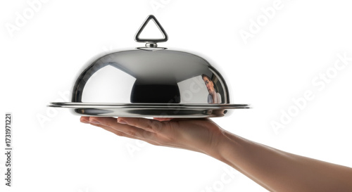 Isolated hand holding domed silver platter with reflection on light neutral backdrop
