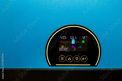 Close-up of a bright blue solar power inverter's digital display, showing real-time system metrics, symbolizing advanced technology for efficient energy monitoring and sustainable power.

