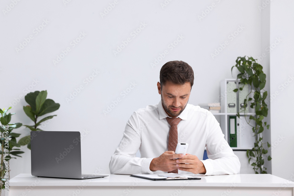 Fototapeta premium Man using remote to control air conditioner in office