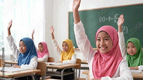 Happy Muslim Schoolgirls Raising Hands In Classroom