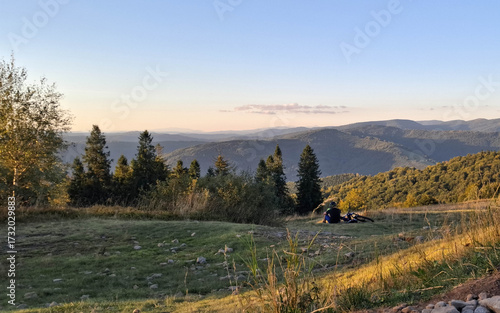 Fototapeta Naklejka Na Ścianę i Meble -  Biker relaxing on a meadow in Beskids.