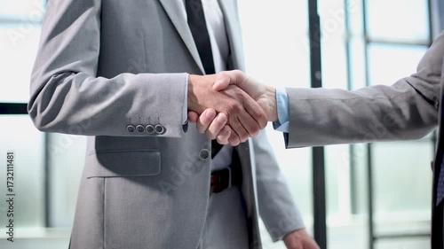 Two men shaking hands in a business setting