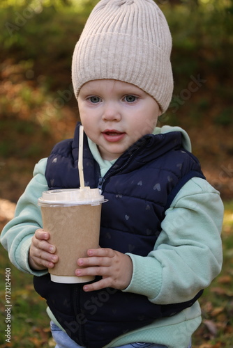 A child with a glass of coffee on the street